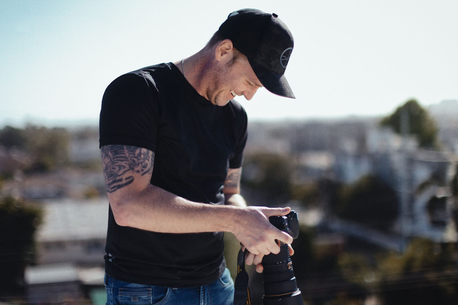 The photographer on a Los Angeles rooftop, checking his camera