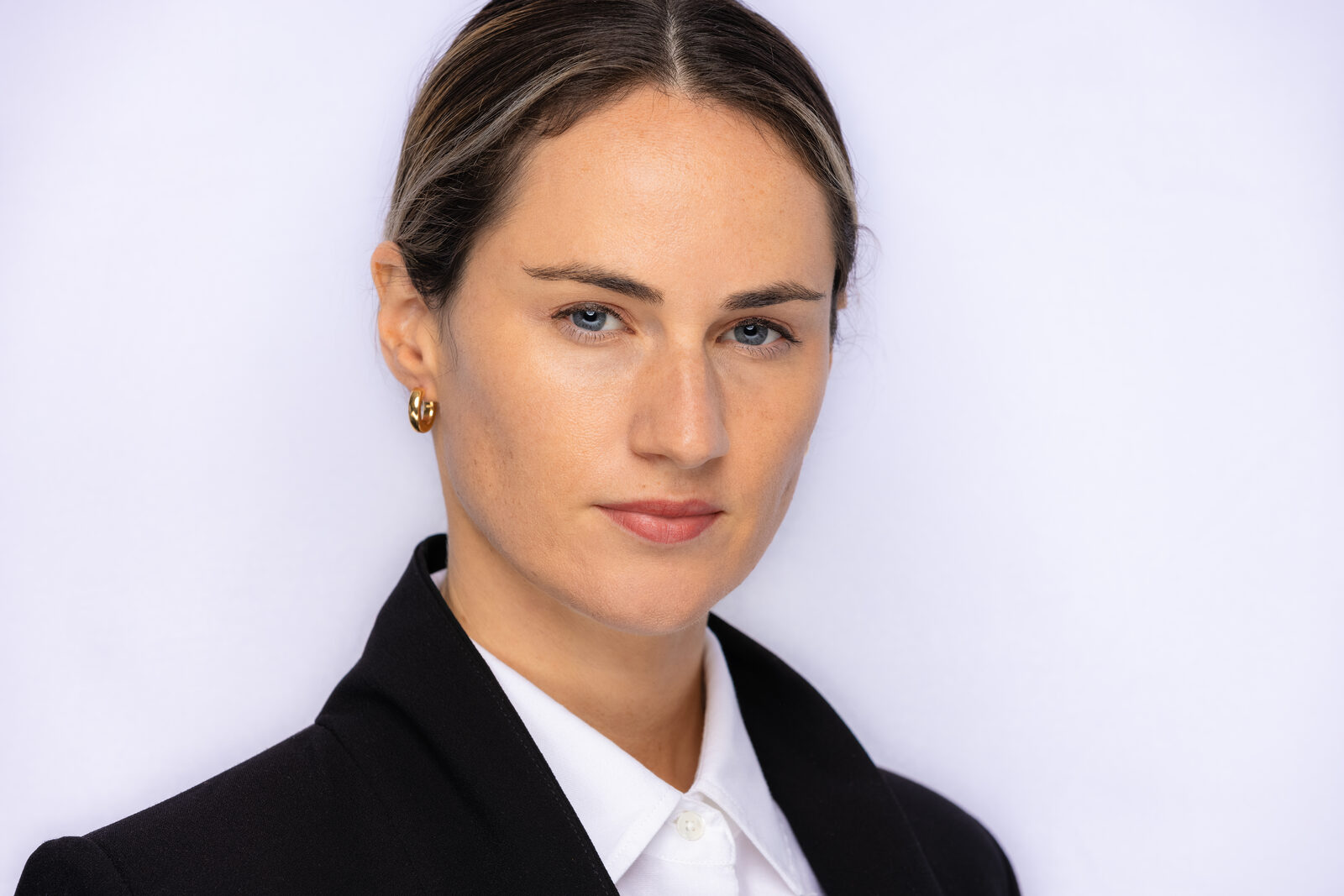 Actor headshot of Whitney in a dark suit and white shirt