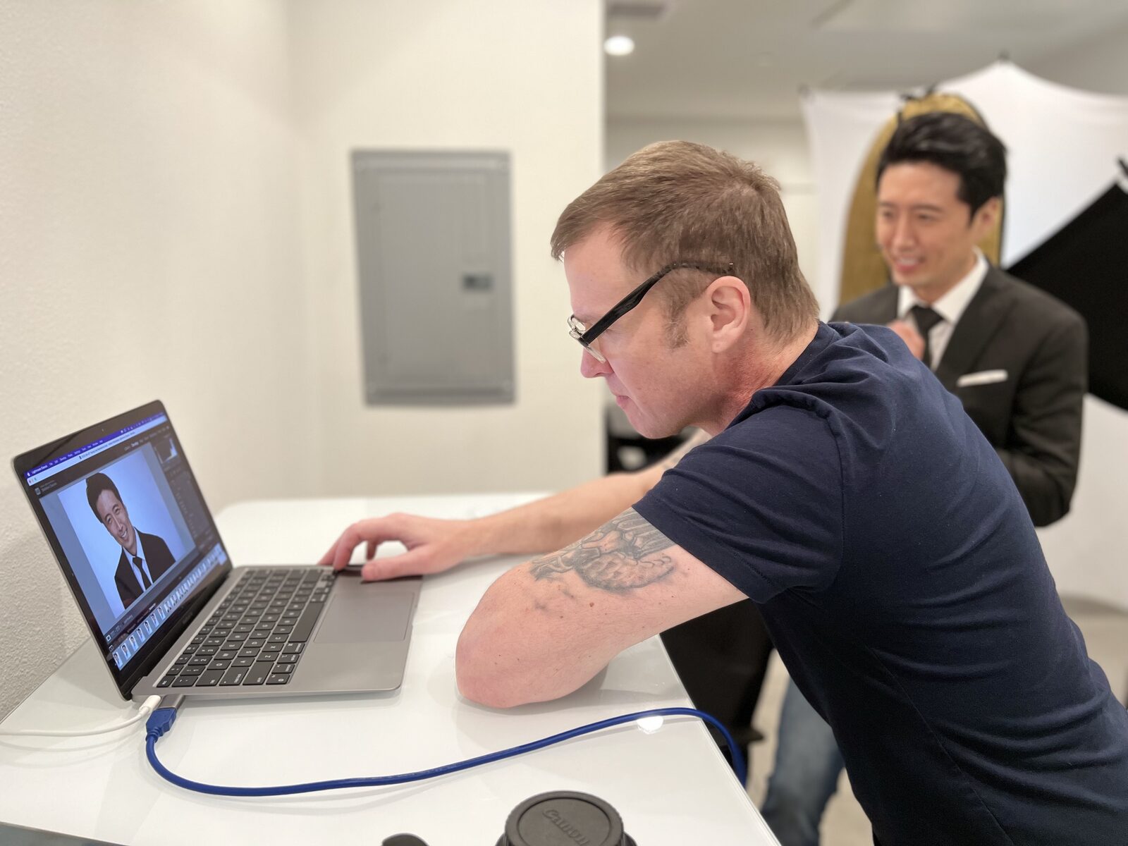 Behind the scenes at the tethered laptop, the client smiling as his new frame comes up on screen